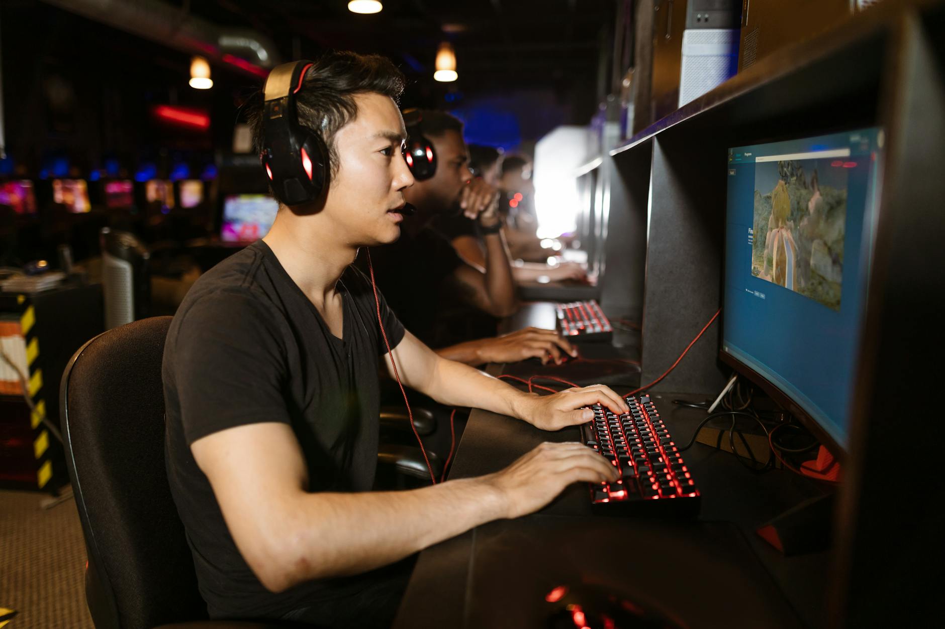 Grupa mężczyzn grających wspólnie w gry MMO w kawiarence internetowej
