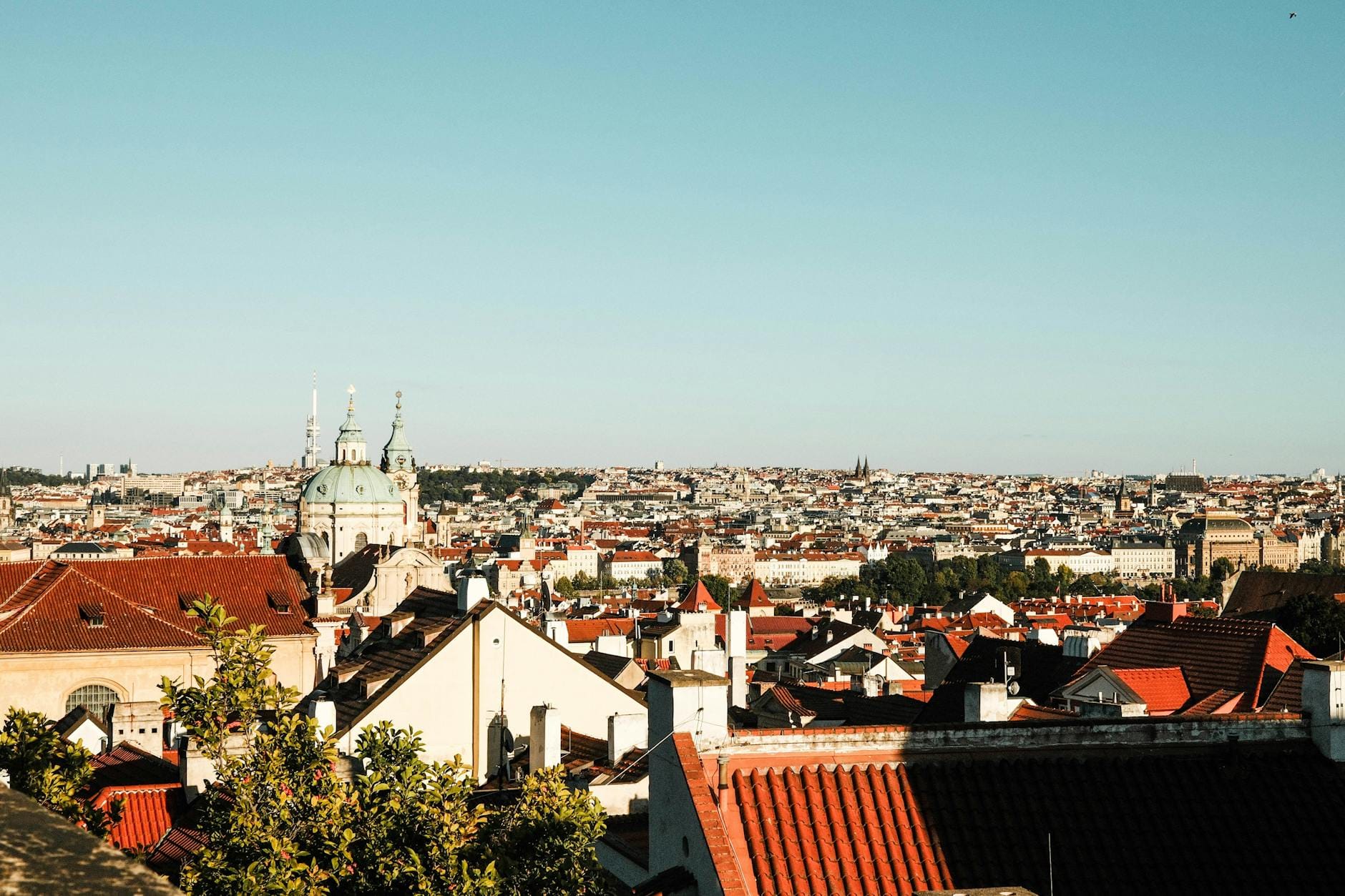 Panorama Pragi z czerwonymi dachami i zabytkowymi wieżami