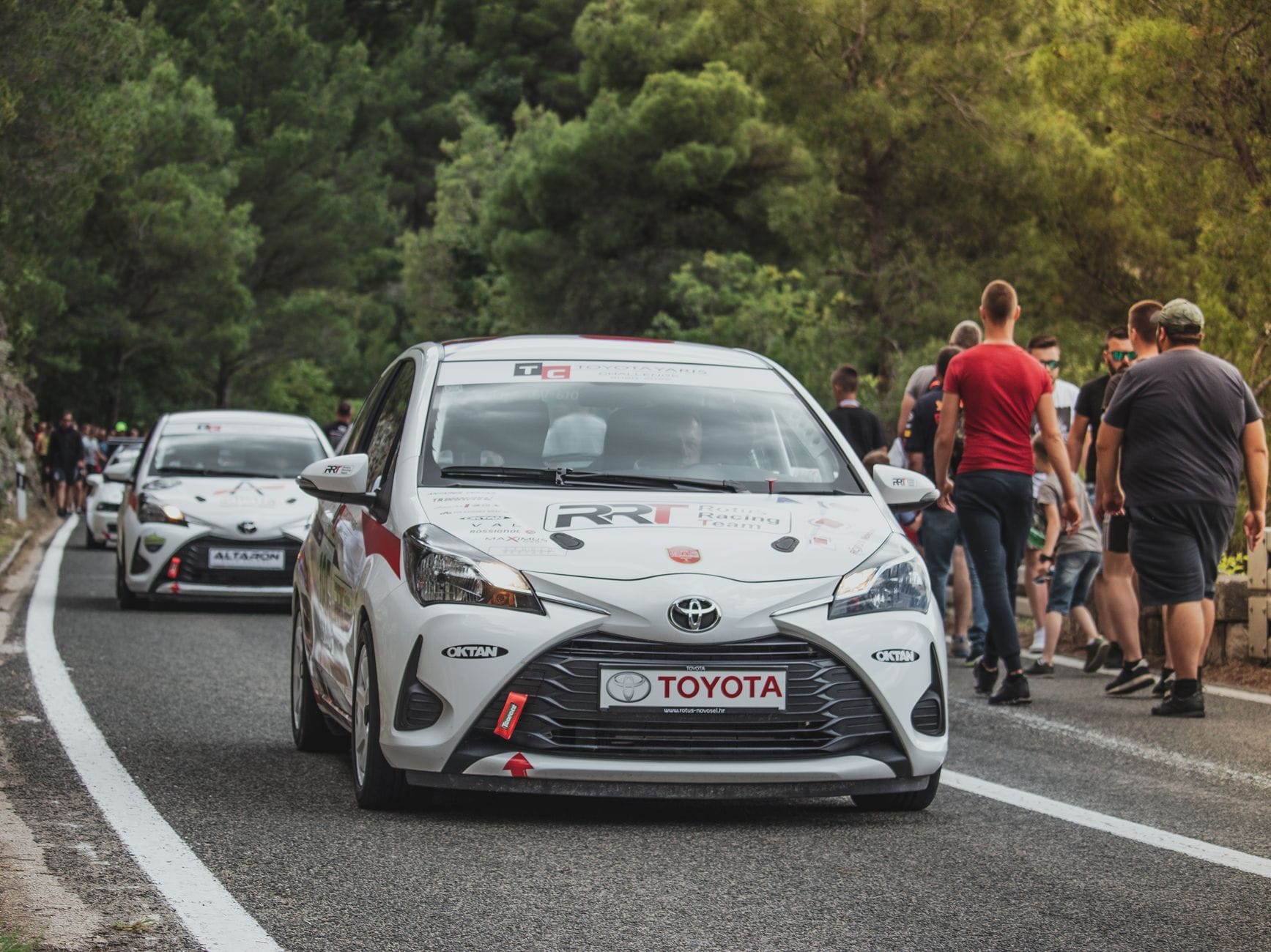 Rajdowa Toyota Yaris pędzi leśną trasą przy dopingu kibiców